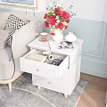 White Nightstand With Open Drawer Camera Book Red Flowers Vase Small Teacup And Magazine
