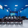 Modern Monitoring Room Interior With Blue Walls Ceiling Multiple Workstations Black Sofas And Windows