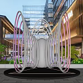 Illuminated Circular Ring Landscape Sculpture In Commercial Area Square With Modern Buildings And Greenery