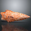 Orange Stone Arrowhead Artifact With Engraved Number 574 And Textured Surface