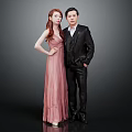 Couple In Pink Gown And Black Suit Against Gray Background