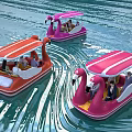 Pink And Orange Flamingo Paddle Boats Carrying People On Water With Canopies