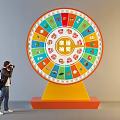 Person Taking Photo of Lucky Draw Wheel With Colorful Icons and Yellow Base