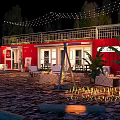 Red Container Building at Night with Outdoor String Lights Plants and Patio Furniture