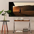 Large Screen Television Displaying Sunset Scene With Man Walking On Metal Stand Near Plant Table