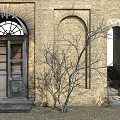 Ancient Architecture Exterior Featuring Brick Wall Arched Doorway Wooden Door And Bare Tree