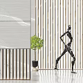 Modern Black Walking Human Figure Sculpture in Interior Space with Striped Wall and Green Plant