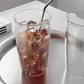 Refreshing Cold Brown Beverage with Ice Cubes in Glass and Empty Glass on Metal Tray
