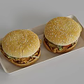 Two Tasty Hamburgers with Sesame Seed Buns Fried Chicken Lettuce Tomato on Light Tray