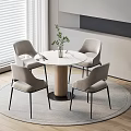 Modern Round Table With Four Light Gray Chairs And Green Plant In Indoor Setting