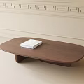 Oval Wooden Coffee Table With White Book On Light Colored Walls And Floor Background