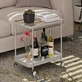 Wheeled Two Tier Side Table With Succulent Books Wine Bottles Flower Vase In Living Room