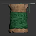 Wooden Spool Wound With Green Thread And Needle Against Dark Background