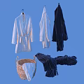 White and Black Bathrobes Hanging On Hangers With Folded Towels In Wicker Basket