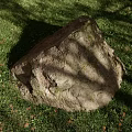 Large Textured Rock Resting on Lush Green Grass With Tree Shadows 3d model