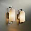 Two Modern Black Metal Wall Sconces With Beige Fabric Shades Mounted On Wall
