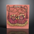 Pair Of Decorative Tassel Ornaments With Embroidered Design On Pink Display Board