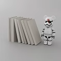 Stack of Gray Books Next to White Black Bear Figurine With Red Markings