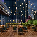 Elegant Outdoor Restaurant Dining Space With Wooden Deck String Lights And Green Hedge Wall