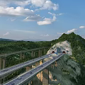 Scenic Mountain Highway Bridge With Tunnel And Forested Surroundings Under Blue Sky
