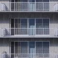 White Metal Grid Design Balcony Railings On Multi story Building With Gray Wall