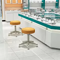 Orange Padded Stools With Metal Wheel Bases In Eyeglass Store Glass Counter Area