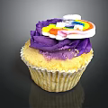 Delicious Cupcake With Purple Frosting And Rainbow Decoration On Black Background