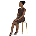Woman In Dark Lace Dress With Updo Hairstyle Sitting On Wooden Chair In Gray Background