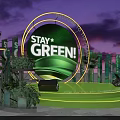 Green Themed Stage With Stay Green Sign And Plant Decorations At Night