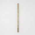Modern Slim Metal Wall Light Featuring Perforated Pattern On White Wall Background