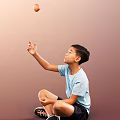 Man Sitting On Floor In Light Blue T-Shirt Raising Right Hand Against Brown Background