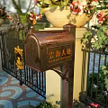 Public Mailbox in Cloud Park with Wrought Iron Gate Flower Pots and Colorful Tiled Floor