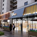 Lively Modern Commercial Street with Shops Pedestrians Trees and High rise Buildings