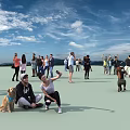 Group of People Enjoying Activities in Outdoor Open Area Under Blue Sky With White Clouds