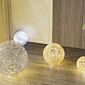 Spherical Woven Floor Lamps In Three Sizes On Wooden Floor With Curtain And Green Plant