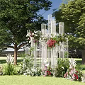 Outdoor Decorative Structure With White Columns And Colorful Flowers On Green Grass