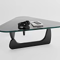 Sleek Modern Glass Top Coffee Table With Black Curved Base And Small Remote Control Device
