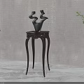 Dark Wooden Side Table With Carved Legs And Abstract Sculptural Vases By Green Plants