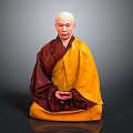 Man in red and yellow traditional robes meditating cross legged with hands clasped