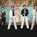 Men Performing Singing On Stage With Microphones And Bright Stage Lights