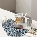 Elegant Tableware Set With Glass Coffee Pot Bamboo Accents And Checkered Cloth On Marble Countertop