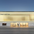 Elegant Illuminated Louis Vuitton Boutique Window Showcase With Unique Golden Patterned Facade At Dusk