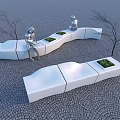 Curved White Landscape Seats With Green Plant Planters And Silver Sculptures On Cobblestone Ground