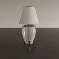 Modern Table Lamp With White Lampshade Transparent Glass Body And Metallic Base On Dark Tabletop
