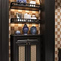 Black Cabinet with Shelves Rattan Doors Displaying Blue White Vases Books on Checkerboard Tile