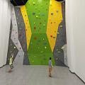 Indoor Climbing Wall With Colorful Holds And People Practicing Climbing