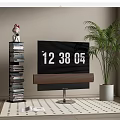 Modern TV with Soundbar on Patterned Rug Near Book Stack and Potted Plant
