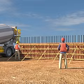 Construction Site With Concrete Mixer Truck Workers In Hard Hats And Orange Vests Constructing Formwork