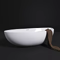 Modern Freestanding White Oval Bathtub With Brown Towel On Dark Background