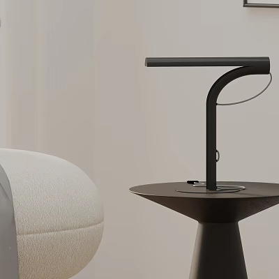 Modern Sleek Black Metal Table Lamp With Curved Arm Placed On Round Small Table 3d model